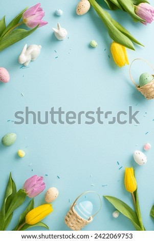 Springtime splendor: tiny ceramic bunnies, fresh tulips, sprinkles, and eggs on a pastel blue canvas. Capture the essence of Easter with this delightful table vertical top view arrangement
