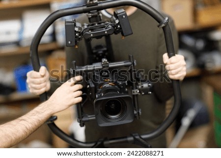 Professional videographer holding camera on gimbal rig steadycam to make video without shaking