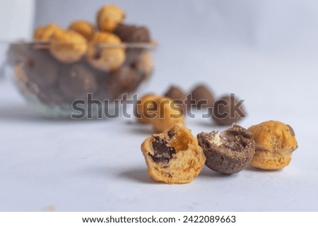 close-up of split chocolate filled eclairs, with a blurred eclairs background. no people.