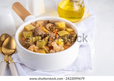Vegetable and meat stew. Hearty meat and vegetable soups or stew, Beef bourguignon with spring vegetables, balanced diet dish in white pot on kitchen white background