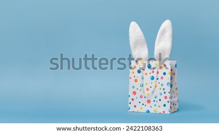 Easter sale, shopping, gift. Easter bunnys ears in a shopping bag, nice funny photo copy space for your text. Blue background