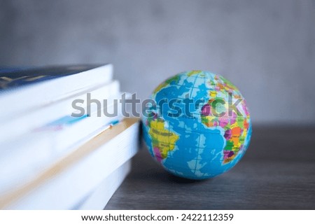 Closeup image stack of books with a globe on a wooden table. Copy space for text. World book day, education and knowledge concept.