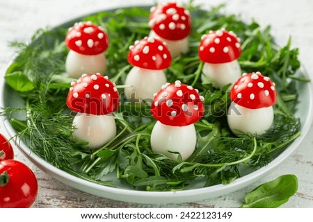 food art idea, edible fly agaric mushrooms made od tomatoes and quail eggs, healthy and funny appetizers Royalty-Free Stock Photo #2422123149