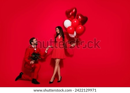 Full body photo of attractive young couple knee propose surprise valentine day wear trendy elegant clothes isolated on red color background Royalty-Free Stock Photo #2422129971