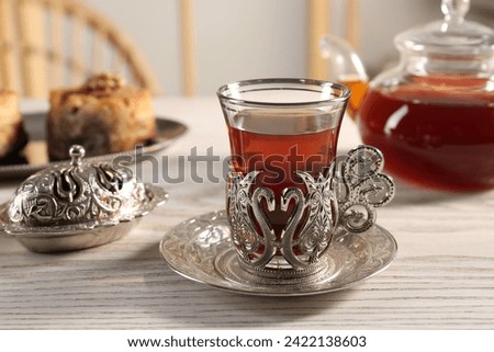 Traditional Turkish tea and sweets served in vintage tea set on white wooden table