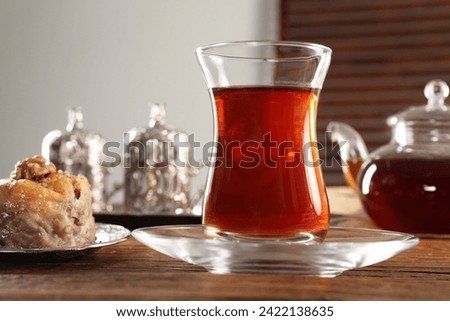 Turkish tea and sweets served in vintage tea set on wooden table, closeup