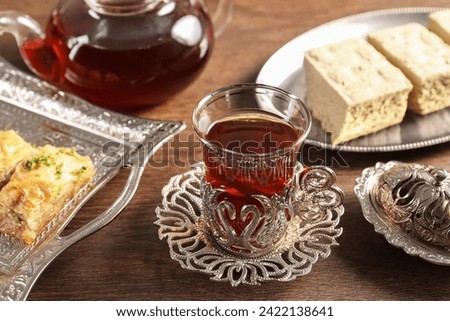 Traditional Turkish tea and sweets served in vintage tea set on wooden table