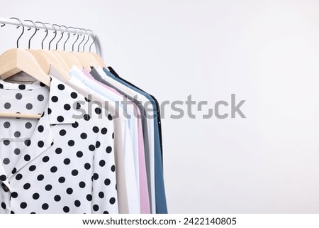 Dry-cleaning service. Many different clothes hanging on rack against white background, space for text Royalty-Free Stock Photo #2422140805