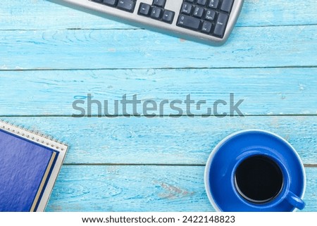 Blue office desk table with computer, pen and a cup of coffee, lot of things. Top view with copy space