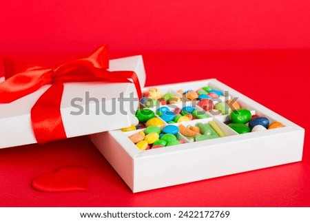 Valentine day composition: sweet candy, with gift boxes with bow and red felt hearts, photo template, background. Perspective with copy space.