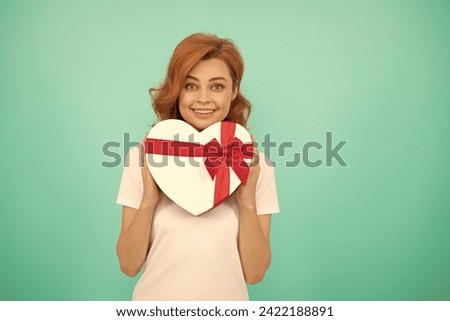 happy woman hold heart gift box on blue background