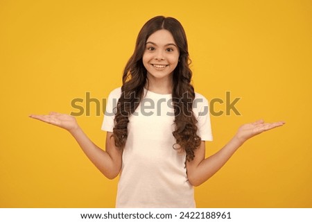 Wow, it's unbelievable. Shocked teenager child pointing aside at copy space. Teen girl pointing with two hands and fingers to the side. Happy teenager, positive and smiling emotions of teen girl.