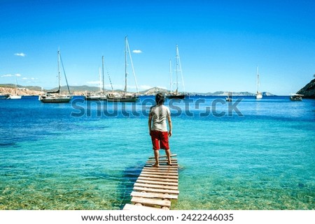 Man from behind in the water at Llentrisca Beach in Ibiza, Balearic Islands, Spain.
