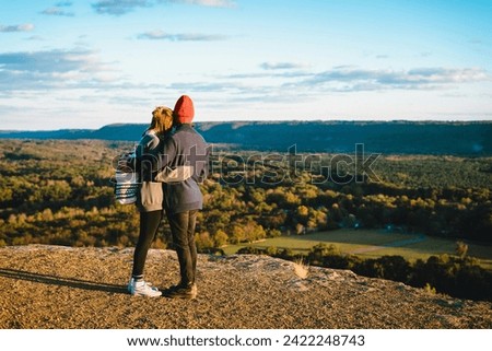 Romantic embrace: A couple gazes at mountain peaks, sharing a heartfelt hug. A scenic moment capturing love amidst the breathtaking beauty of nature. Royalty-Free Stock Photo #2422248743
