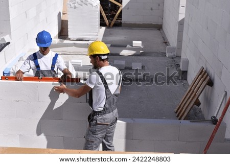 teamwork on the building site - construction workers build a family home 