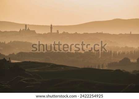 Elevated panorama view of Crete Senesi landscape and city of Siena at sunrise. Tuscany, Italy. Royalty-Free Stock Photo #2422254925