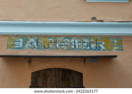 Weathered barber shop sign ("barbiere" in Italian) on the facade of an old building, Italy