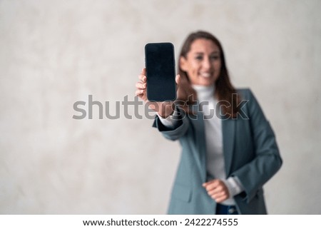 Portrait, happy woman, phone screen for business news, studio commercial promo or brand logo design. Online corporate info, cellphone mockup space or model web notification on gray background. Royalty-Free Stock Photo #2422274555