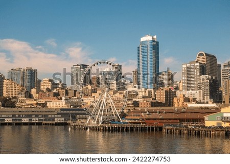 Seattle skyline with Waterfront neighborhood and ferris wheel in foreground.