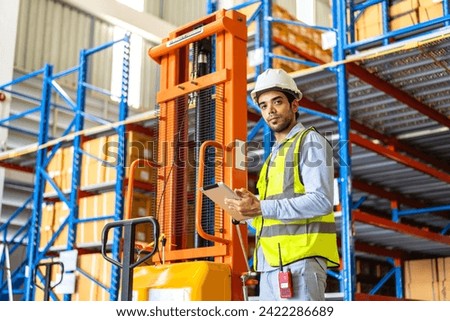 Portrait engineer man shipping order detail check goods and supplies on shelves with goods background inventory in factory warehouse.logistic industry and business export