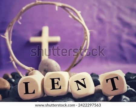 Lent Season, Holy Week and Good Friday Concepts. LENT on wooden cubes with blurry cross and crown of thorns in purple colour background. Stock photo