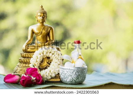 Sprinkle water onto buddha with water with flowers , thai traditional perfume and Jasmine garland to worship during the Thai Songkran festival. Royalty-Free Stock Photo #2422301063