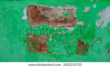 Close-up photo of a damaged green wall


