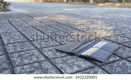 Image of dropping your wallet outdoors. Royalty-Free Stock Photo #2422320005