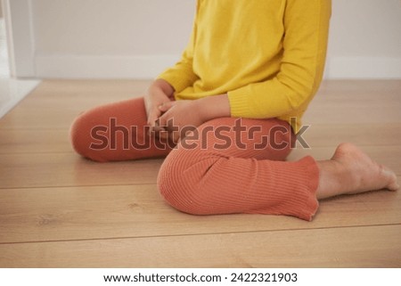  child sitting W posture on the floor . Royalty-Free Stock Photo #2422321903