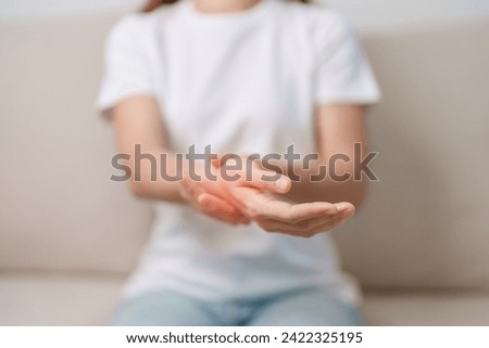 Woman having wrist pain during sitting on sofa at home, muscle ache due to De Quervain s tenosynovitis, ergonomic, Carpal Tunnel Syndrome or Office syndrome concept Royalty-Free Stock Photo #2422325195