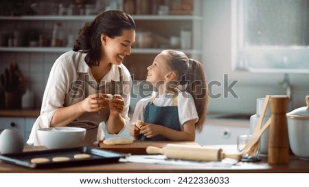Happy loving family are preparing bakery together. Mother and child daughter girl are cooking cookies and having fun in the kitchen. Homemade food and little helper.  Royalty-Free Stock Photo #2422336033