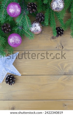Christmas tree branches with red decorations on a wooden wall background. Template for greeting card or design. Virtical banner with copy space.