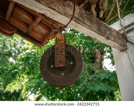 An old rusty pulley used to draw water from a medieval well in Java