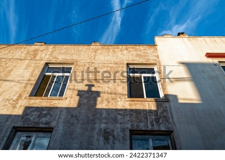The shadow of a chimney on the exterior wall of a building