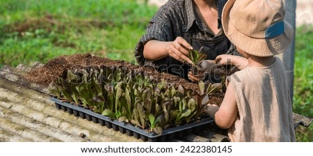 Gardener Mother teaching son how to plant in garden, family relationship concept