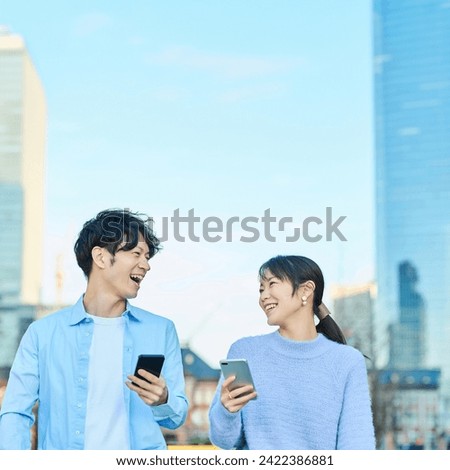 Smiling man and woman with smartphone in hand