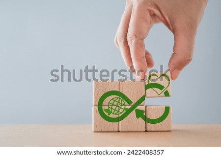 ESG Environmental, Social and Corporate Governance sustainability and ethical business.Hands arranged wooden cube block with infinity heart and green world icon, including copy space