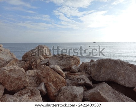 Gray coral rocks on the beach and under a cloudy sky during the day