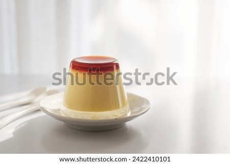 Homemade caramel custard pudding in an upside down glass on a plate, how to unmold caramel pudding. Royalty-Free Stock Photo #2422410101