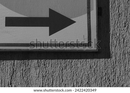 Arrow symbol , street sign to the right side direction. Wall background. Street pointer. This way concept. Black and white, monochrome.