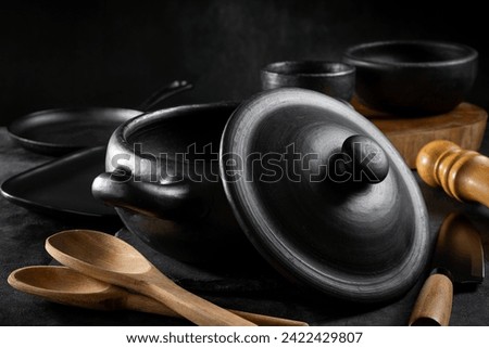 Black pots, pans and kitchen utensils.