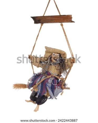 Halloween witch flying on broom isolated on white background. Handmade toy, Baba Yaga