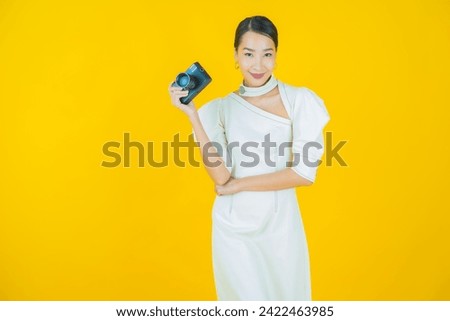 Portrait beautiful young asian woman use camera on color background
