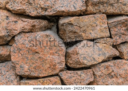 It's photo of red stone wall of building. This is close up view of a stone background texture.