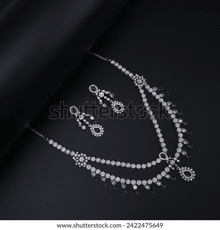 silver jewelry with small red stones inside with black background (backdrop) photoshoot 