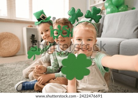 Cute kids celebrating St. Patrick's Day with clovers at home party Royalty-Free Stock Photo #2422476691
