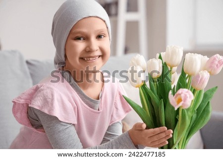 Little girl after chemotherapy with tulips at home, closeup. International Childhood Cancer Day Royalty-Free Stock Photo #2422477185