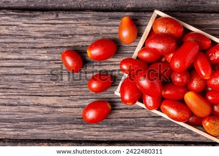 Organic cherry tomatoes harvested at home with top view and selective focus on a rustic wooden table