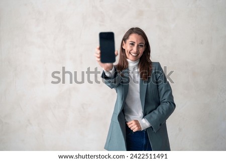 Studio portrait of businesswoman with phone for product placement, branding and mobile app advertising, marketing mockup, online corporate info, web notification. Royalty-Free Stock Photo #2422511491