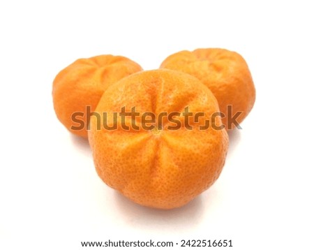 Closeup of photo of three juice mandarines from the Greek island of Chios, isolated on white background.
